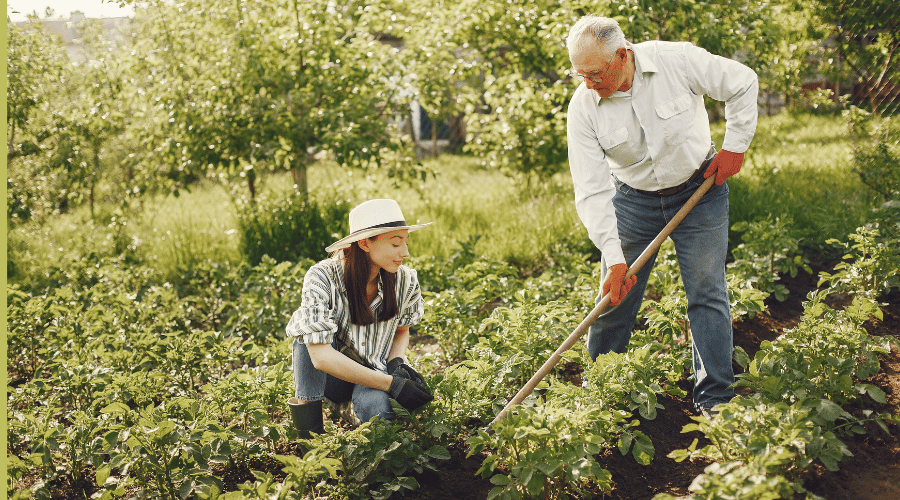 Enkelin und Großvater bei der gemeinsamen Gartenarbeit