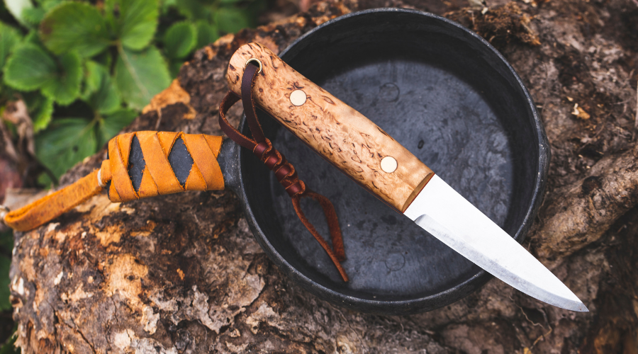 Gartenmesser mit ergonomischem Griff und scharfer Klinge auf einer Holzunterlage neben frischem Gemüse